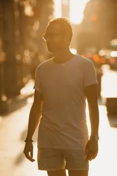 A man in sunglasses standing in the rays of the sunset on a street in Valenci Stock Photos