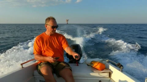 Man with sunglasses steering motorboat while using smartphone Видео 279902278