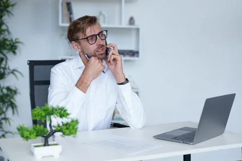 Man with sunglasses works in office with computer. Stock Photos