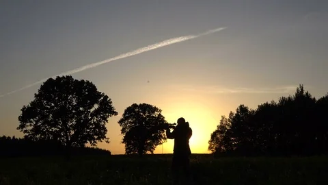 Man on a sunset background with gun 4k 스톡 동영상 80326183