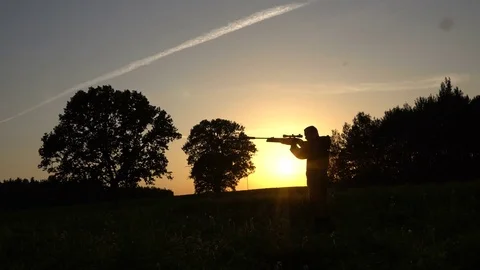 Man on a sunset background with gun Video stock 80326297
