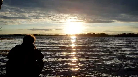 Man at sunset on the background of the lake Stock Footage 131022532