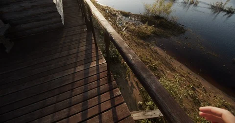 Man at sunset goes over the bridge and holds the railing Stock Footage 115986257