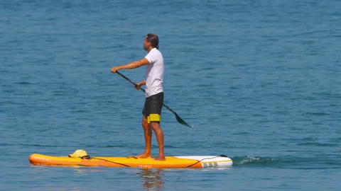 Man on a SUP board with a paddle Stock Footage 243419534