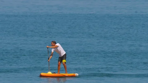 Man on SUP board in the sea Stock Footage 242833142