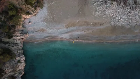 A man on a SUP board on the shore of a wild beach in a beautiful bay Stock Footage 232002144