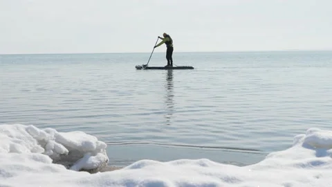 Man Sup-boarding in winter. Stand Up Paddle surfing Stockbeeldmateriaal 170543296