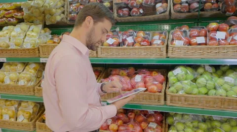The man in supermarket makes a purchase using a tablet Stock Footage 63372232