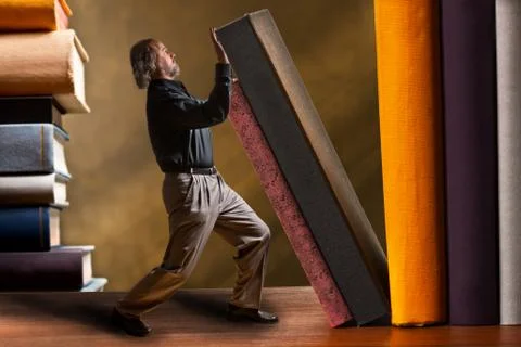 Man supporting falling book in the bookshelf Stock Photos