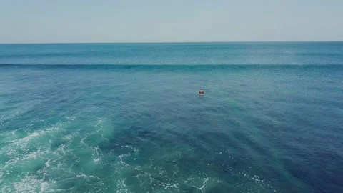 A man on surfboard floating in the middle of the blue ocean relaxing on summer. Stock Footage 131954721