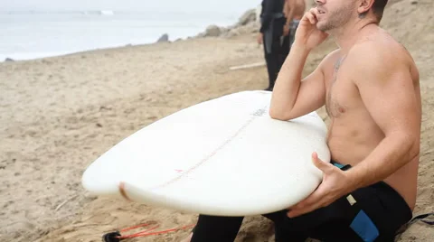 Man with surfboard talking on cell phone Stock-Footage 61662683