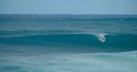 Man, Surfer, Rides a Large Blue Ocean Wave, Slow Motion Stock Footage 127520848
