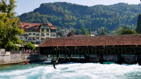 Man Surfer Riding the Wave on River Aare with an Old Bridge Obere Schleuse 库存影片 265492813
