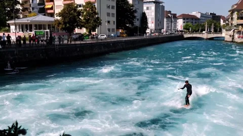 Man Surfer Riding the Wave With a Rope on River Aare in City of Thun Stockbeeldmateriaal 265492811
