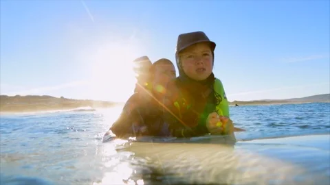 Man surfing with his two daughters. 库存影片 88405988