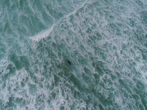Man surfing the waves, aerial view above the sea Stock Footage 77507053