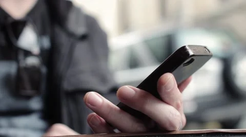 Man Surfing Web On Smartphone Sitting Outside Stock Footage 63089721