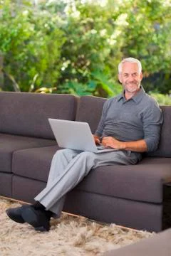 Man surfing the web on sofa Stock Photos