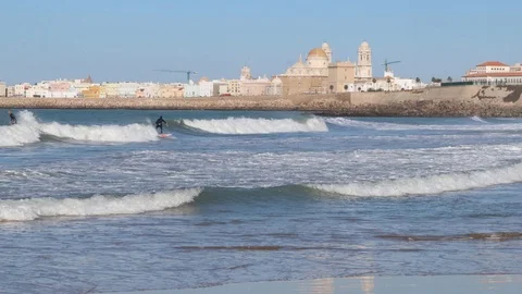 Man surfs sea on the beach in Cadiz in sunny autumn Stock Footage