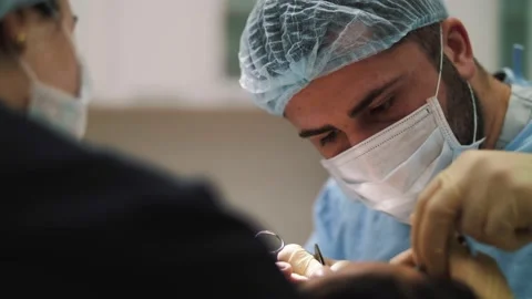 A man surgeon performs face and hands surgery close-up Stock Footage 160938744