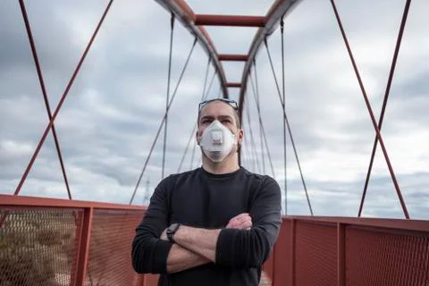 Man with surgery mask looking at camera in pedestrian bridge Stock Photos