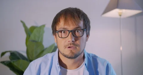 A man in surprise shoots glasses and looks at the camera in surprise Stock Footage 123727670