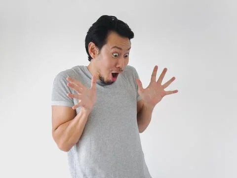 Man with a surprised expression on his face is wearing a gray shirt Фото