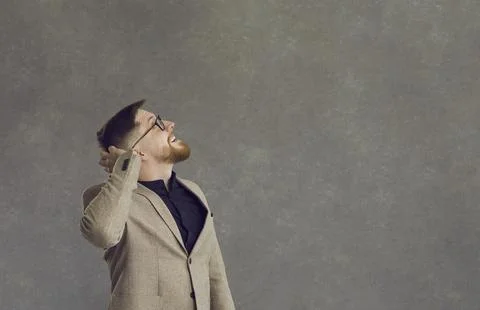 Man with a surprised expression scratches the back of his head, not knowing what Stock Photos