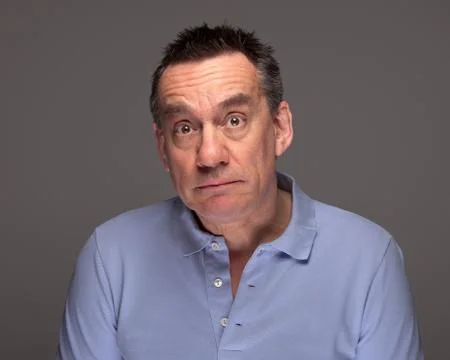 Man with surprised sad expression on grey background Foto stock