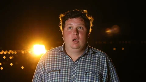 Man surprised by something by shakes his head and opens his mouth at night Stock Footage 101397014