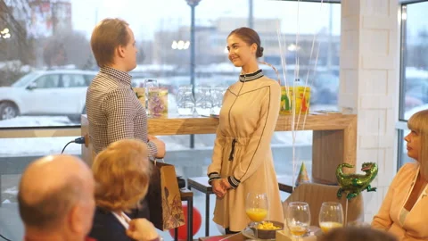 Man surprising his girlfriend with a gift in restaurant Stock Footage 87976261
