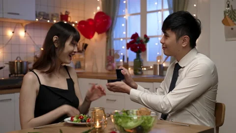 Man surprising his girlfriend with a gift ring Stock Footage 168372446