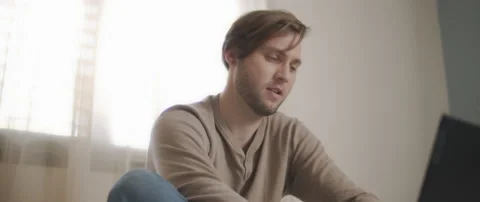 A man surprisingly looking on the screen of a laptop while working from home Stock Footage 135095744