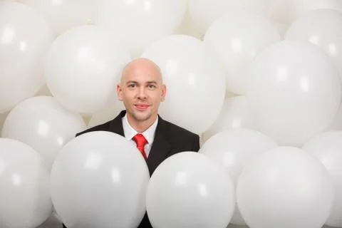 Man surrounded by balloons at corporative party Stock Photos