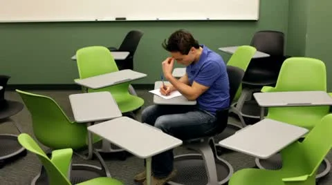 Man surrounded by chairs in classroom Stock Footage 10699633