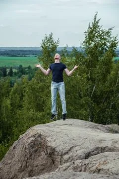 A man surrounded by mountains and forests. A man in a jump Stock-Fotos