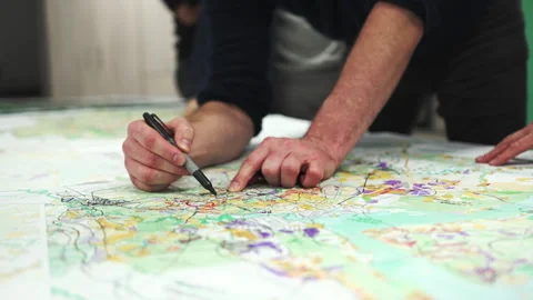 Man surrounded by team uses marker to jot down notes on map Video stock 290523106