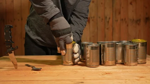 Man survivor preparing meal from old canned food, survival escape in forest.. Stock Footage 325635156
