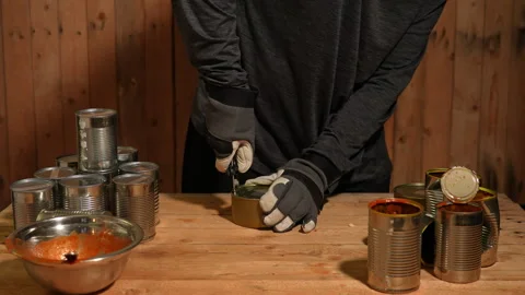 Man survivor preparing meal from old canned food, survival escape in forest.. Stock Footage 325635211