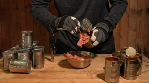 Man survivor preparing meal from old canned food, survival escape in forest.. Stock Footage 325635220