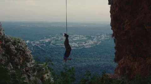 Man Suspended From Feet Between Cliffs Stock Footage 275478775