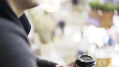 Man in a sweatshirt drinking a coffee to go outdoors 스톡 동영상 80965639