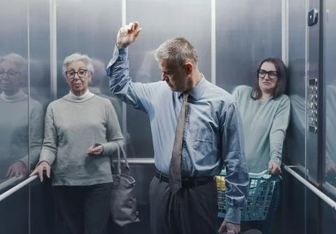 Man with sweaty armpits in a crowded elevator Foto stock