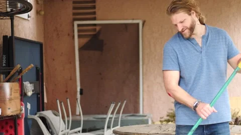 Man sweeping in backyard cleaning up Stock Footage 154763390