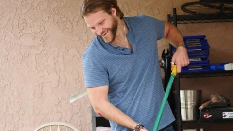 Man sweeping in backyard cleaning up Stock Footage 154763416