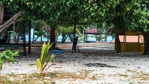 A man is sweeping the beach Stock Photos
