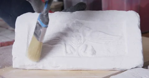 Man sweeps dust from plaster mold for casting to see pattern Stock Footage 171043648