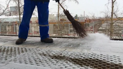 A man sweeps snow with a broom Vídeos de archivo 129755636
