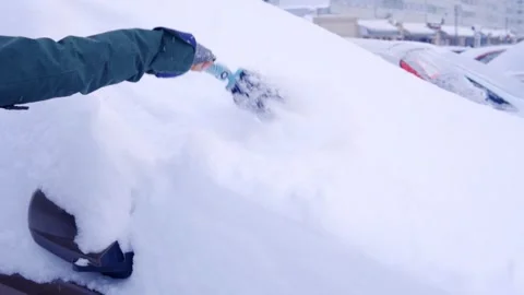 Man sweeps snow from a car in winter. Close-up Stock Footage 145458971