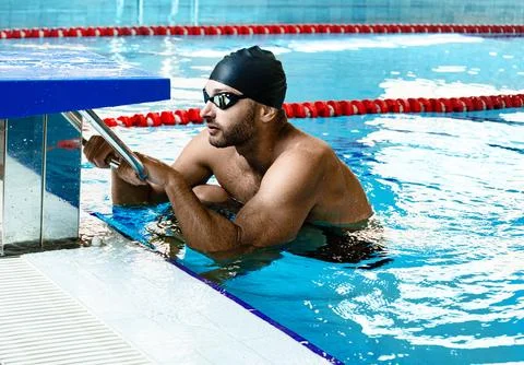 Man swimmer getting ready to start swimming in a swimming pool. Professional  写真素材
